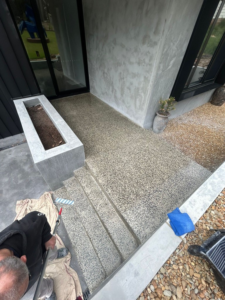 Concrete entry steps with exposed-aggregate finish at modern home