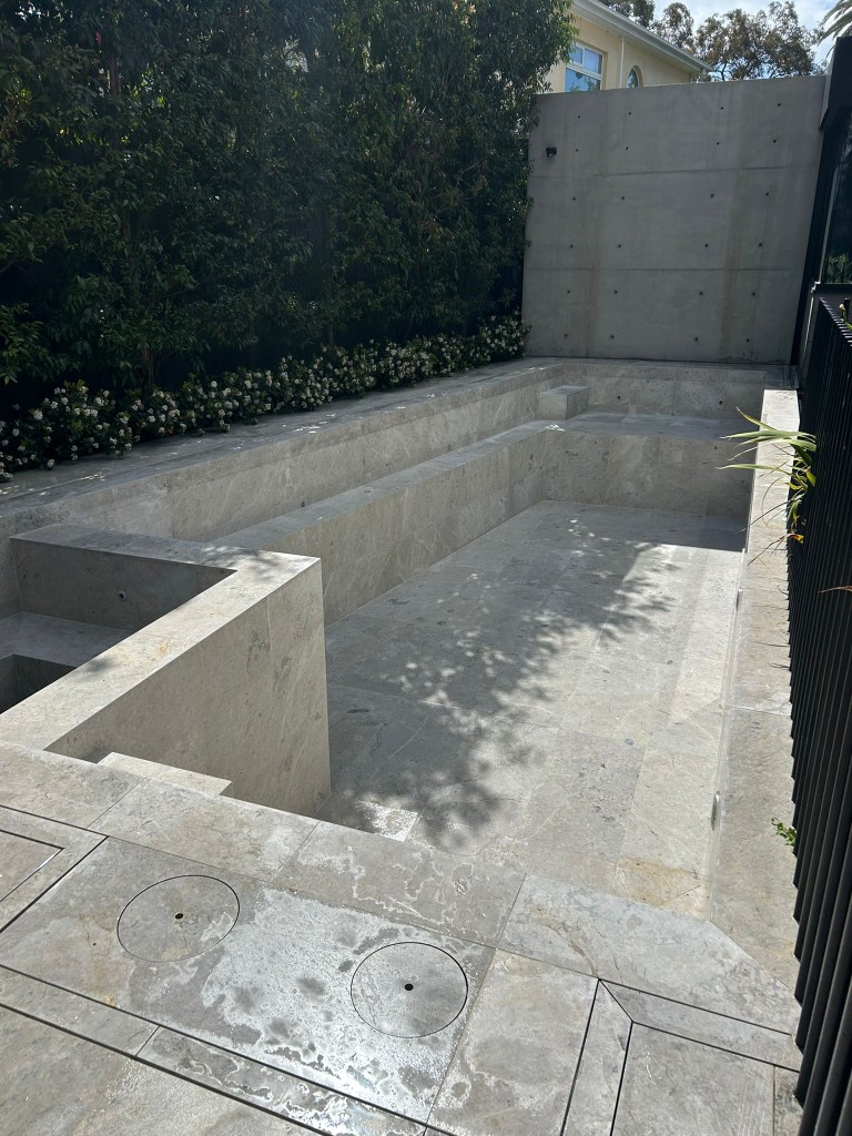 Custom-cut limestone for sunken pool and spa under construction